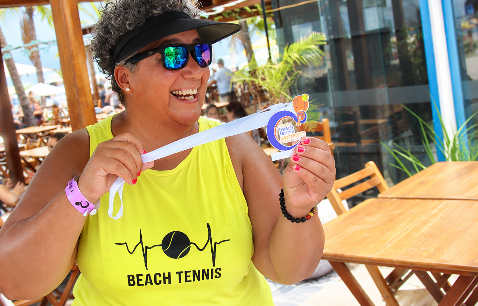 Participante do torneio exibindo sua medalha de Beach Tennis.