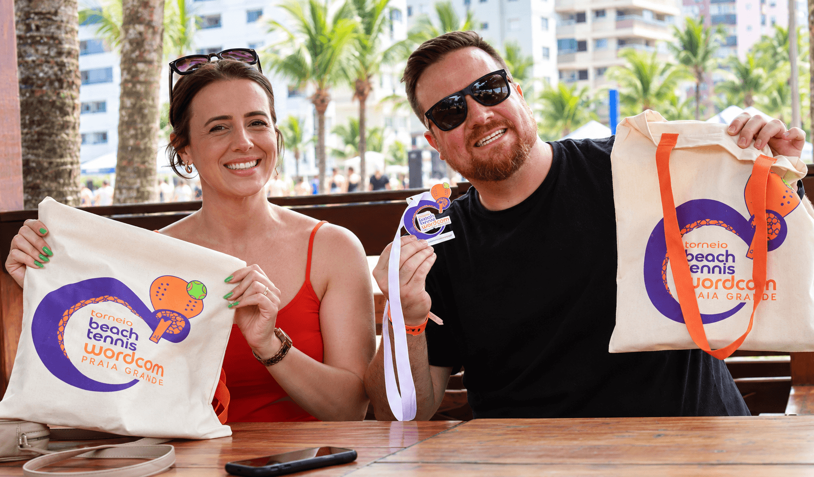 Participantes sorrindo no torneio de Beach Tennis.