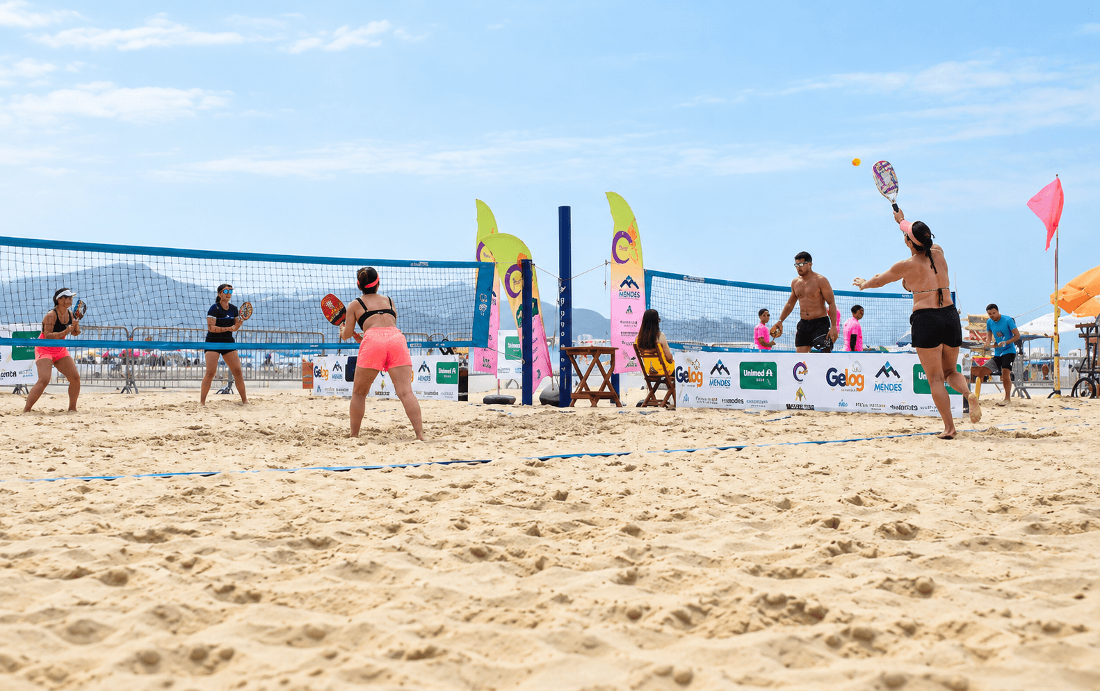 Quadras e participantes do torneio de Beach Tennis à beira-mar.