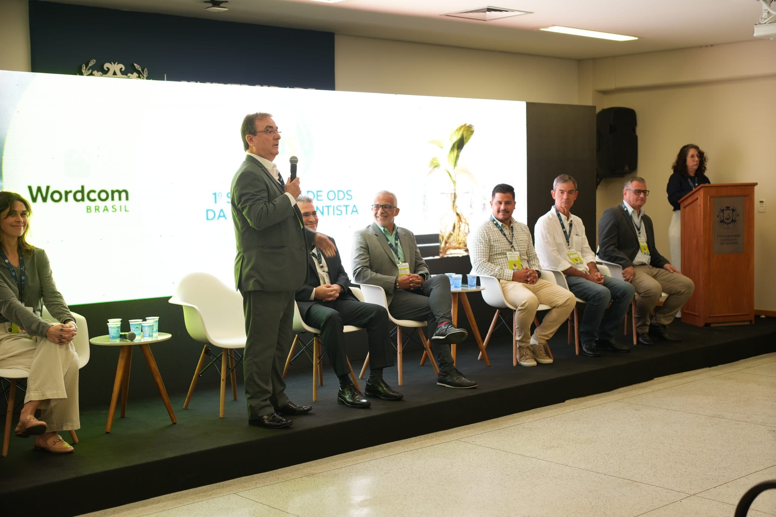 Palestrante com microfone durante um painel do seminário