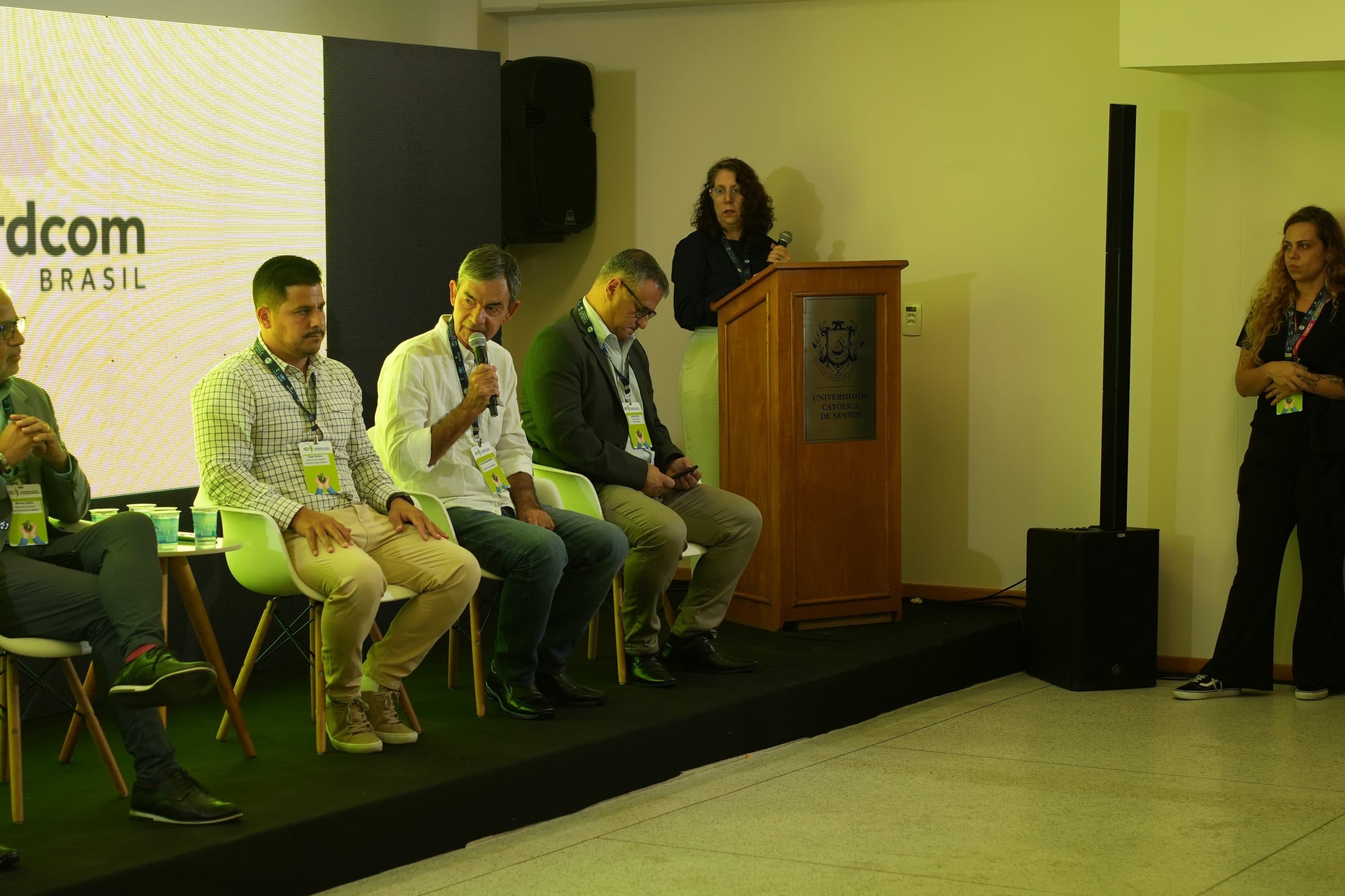 Apresentação no púlpito ao lado dos participantes do painel